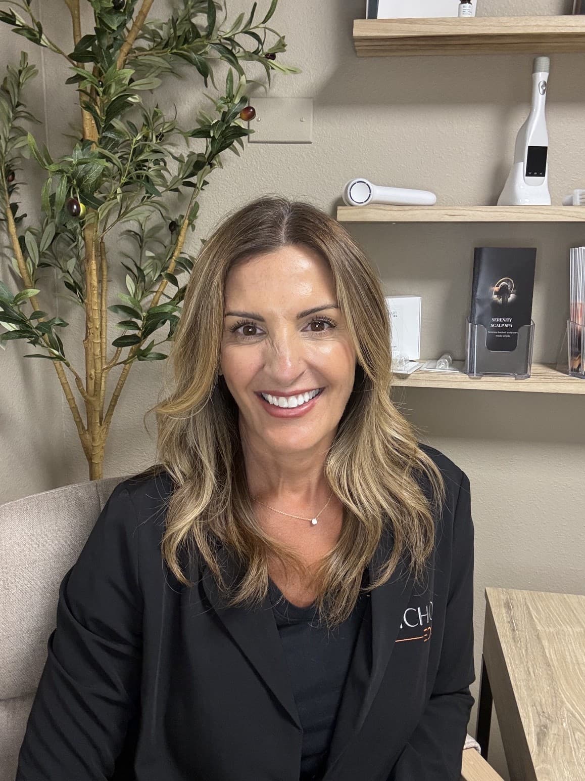 Carisa, founder and certified trichologist, smiling in the Serenity Scalp Spa studio