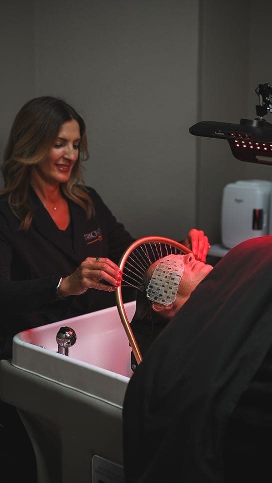 A specialist adjusting the therapy halo over a guest at the basin